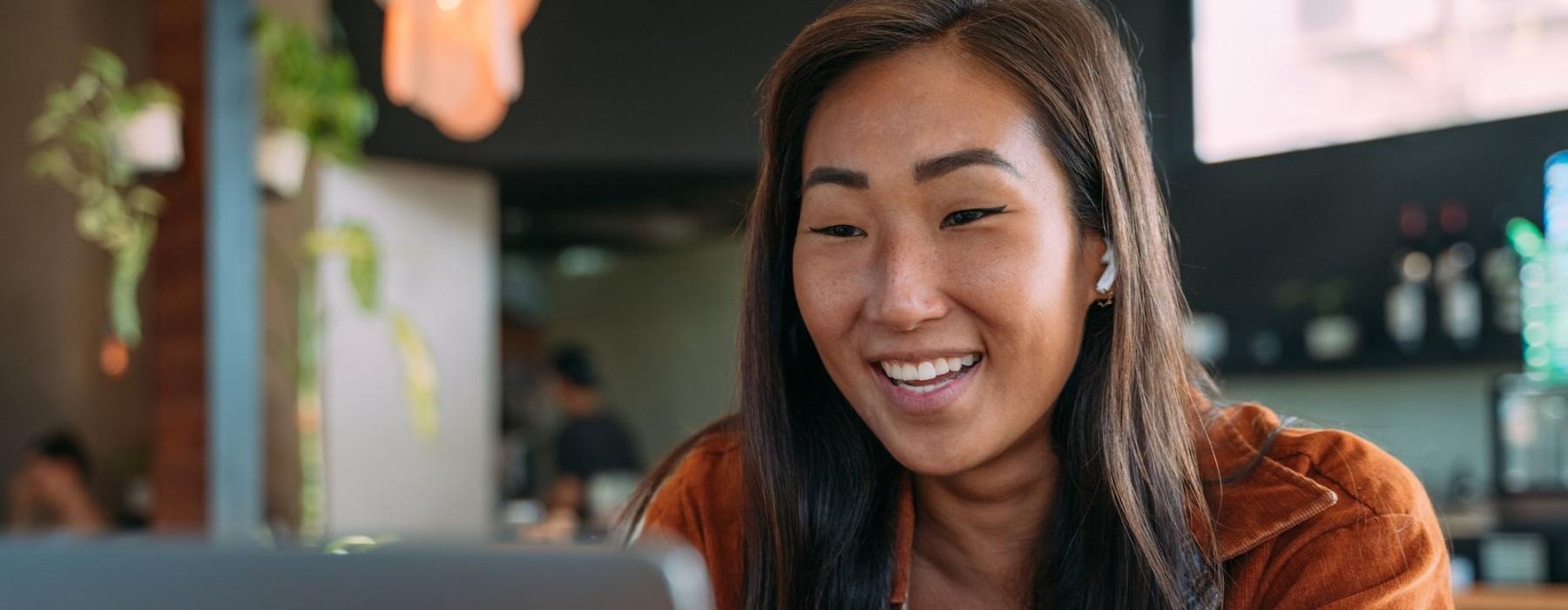 a woman smiling while working on laptop