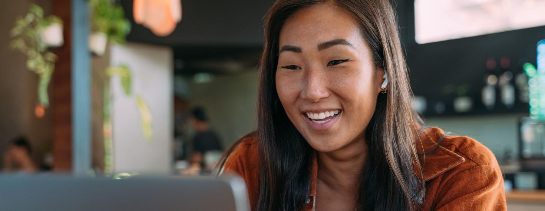 a woman smiling while working on laptop